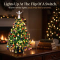 Fleva beaded Christmas tree kit lit up with warm-white lights on a table by the fireplace