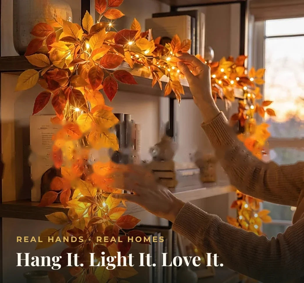 Hands draping the light-up autumn leaf garland along a bookshelf — hang it in minutes, no tools needed